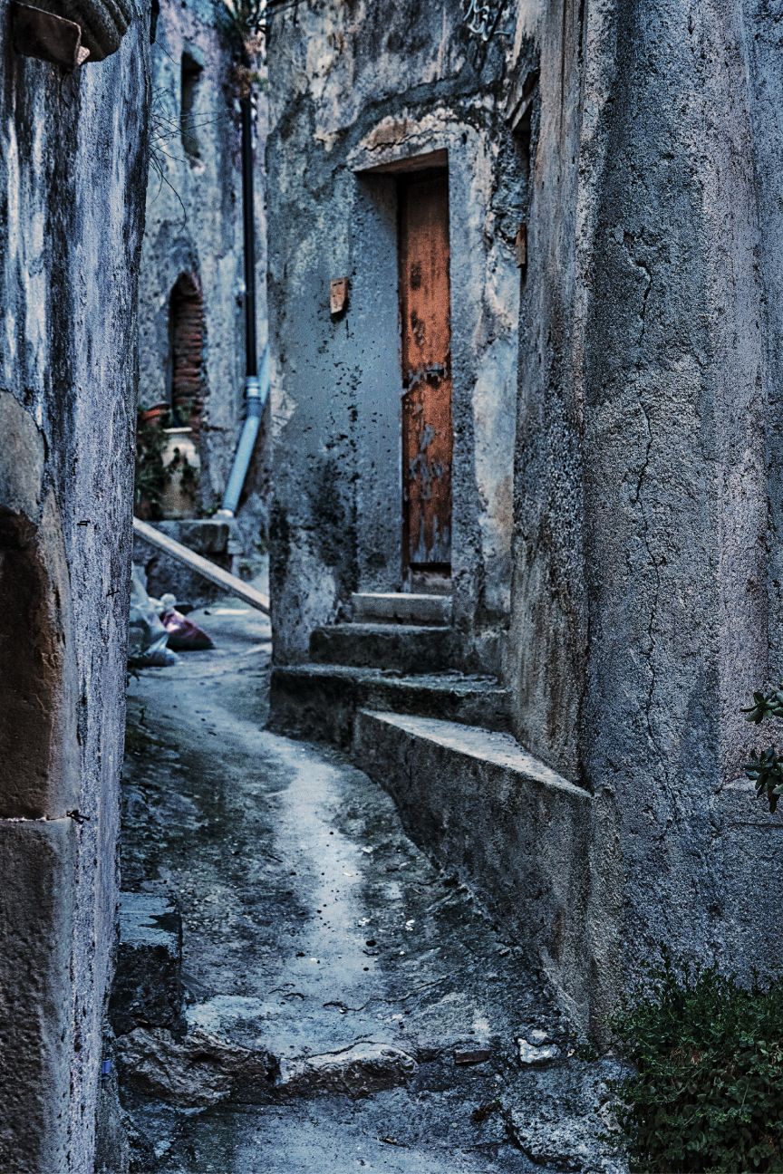 Narrow winding alleyway with weathered stone walls and rustic doorways in an ancient Mediterranean village
Horvath-Photography-Sam-Sciarrino