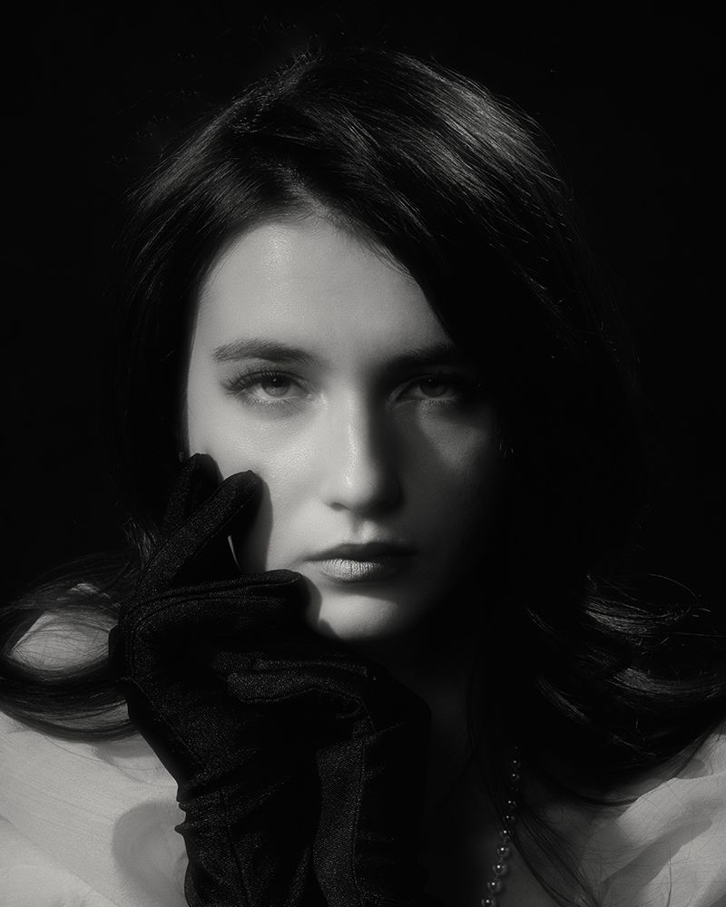A series of dramatic black and white portrait shots showing dark hair against shadowy backgrounds.