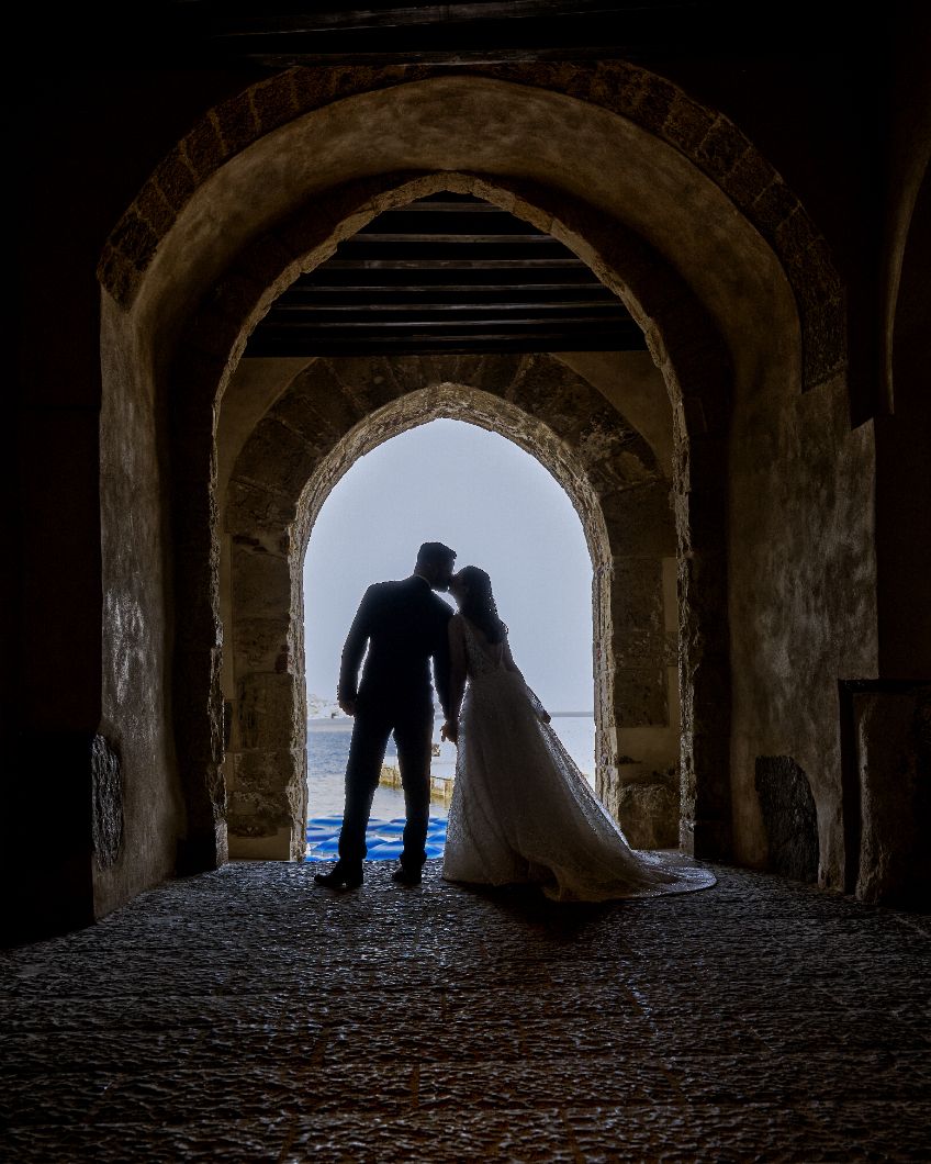 Silhouettes of figures framed within dark stone archways overlooking a bright outdoor view.
Horvath-Photography-Sam-Sciarrino