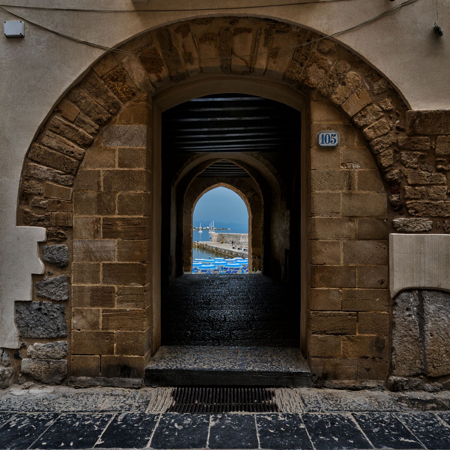 Stone archway in Sicily reveals a glimpse of a Mediterranean harbor through multiple passageways.
Horvath-Photography-Sam-Sciarrino