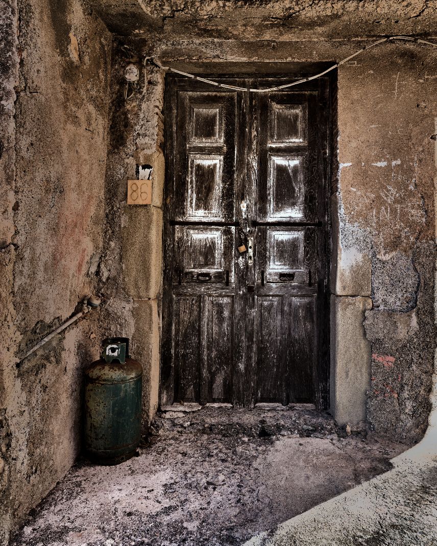 Four dark doorways in a dilapidated concrete corridor with crumbling walls and debris-covered floors.
Horvath-Photography-Sam-Sciarrino