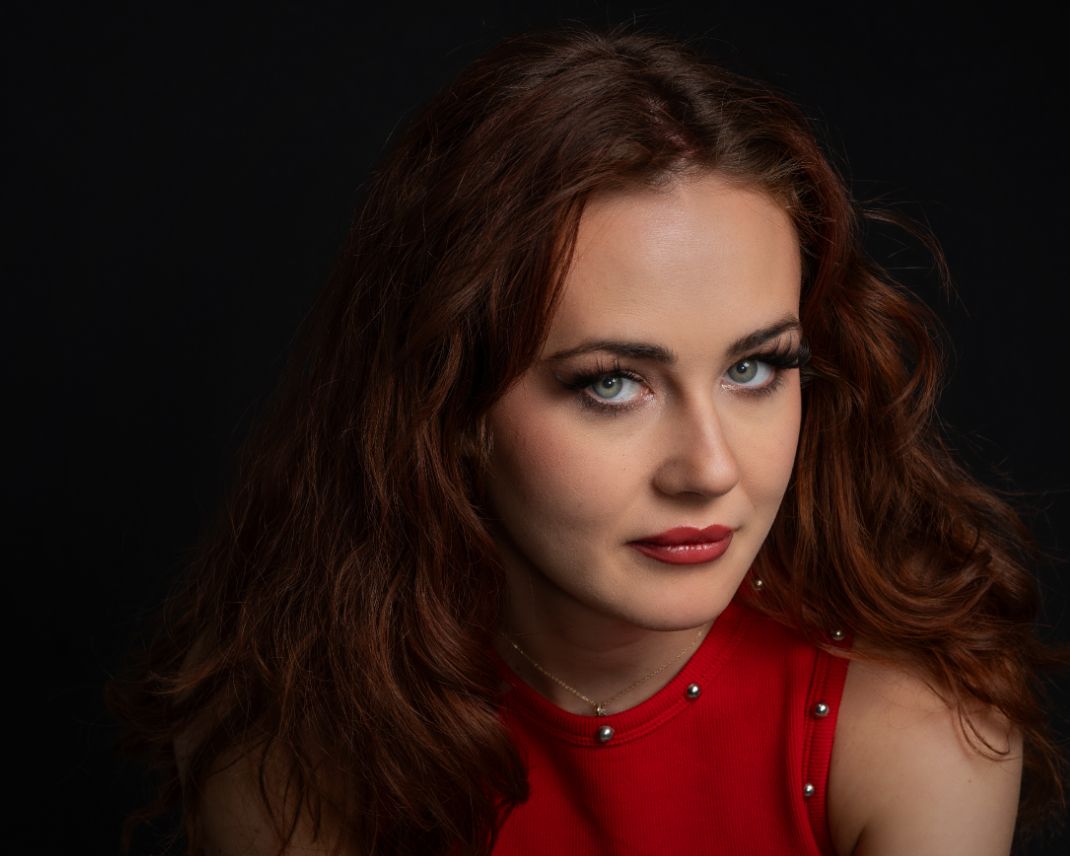 Dramatic studio portraits featuring a red dress and moody lighting against a black background.