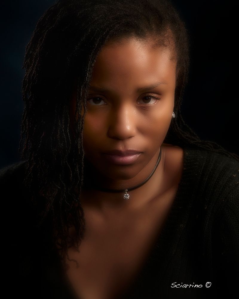 A series of dramatic portrait photographs in low key lighting showing different angles and expressions against a dark background.