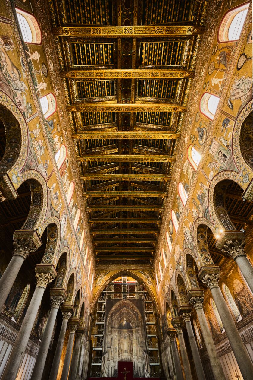 Interior panorama of the Norman Palatine Chapel in Palermo showing ornate Byzantine mosaics and golden ceiling details.
