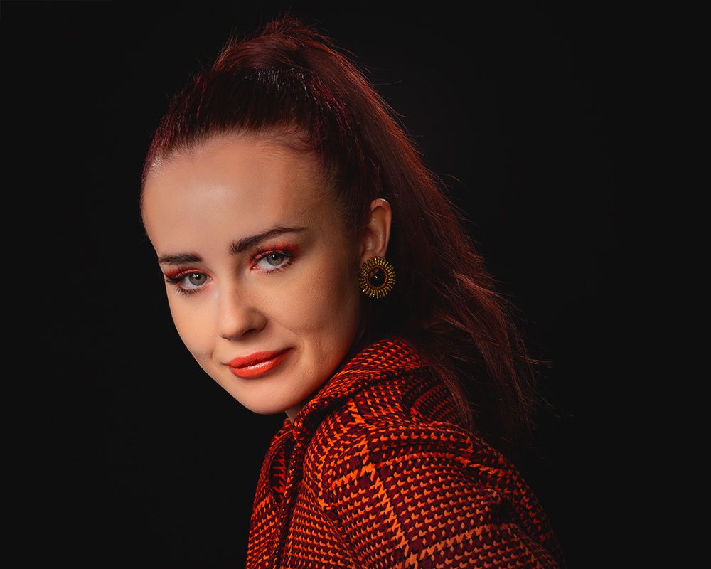 Portrait series showing a model in a red polka dot jacket against a dark background.