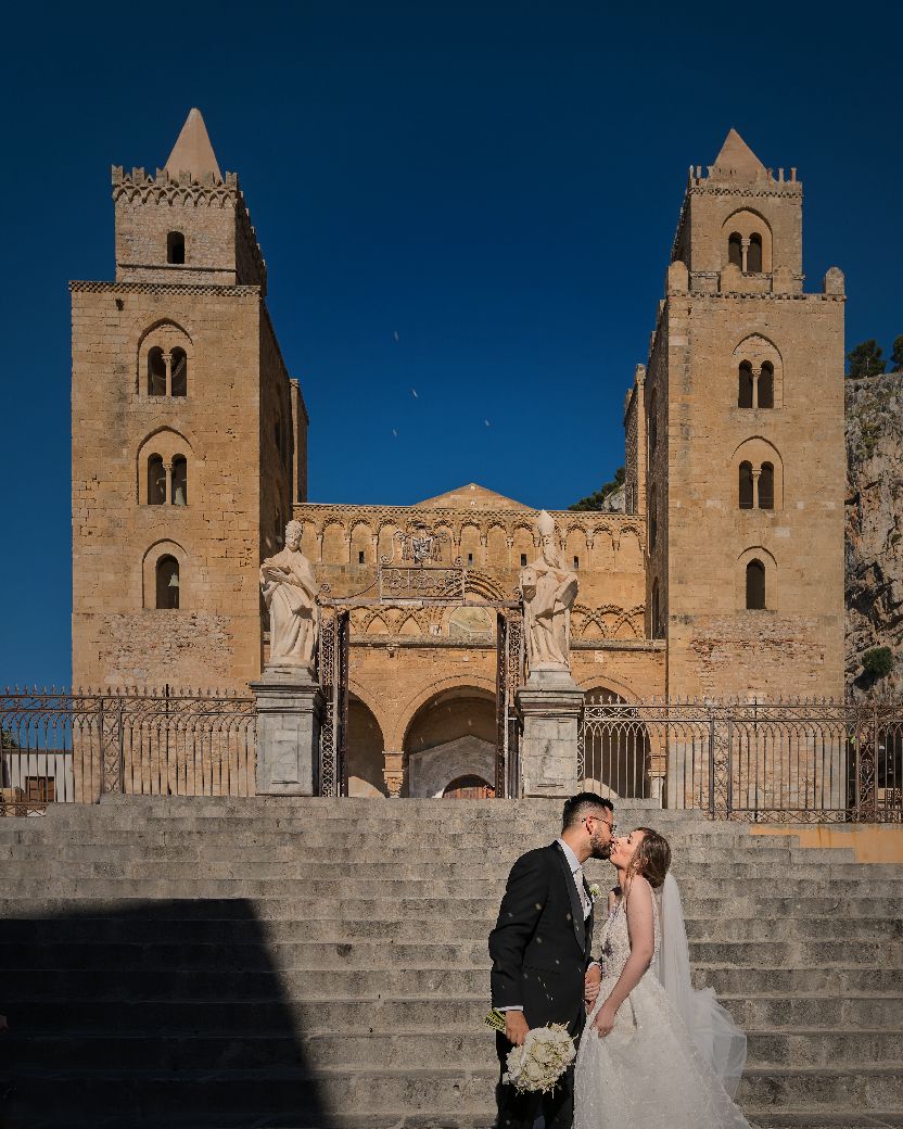 A couple shares a romantic moment on stone steps in front of a majestic cathedral with twin towers at sunset.
Horvath-Photography-Sam-Sciarr