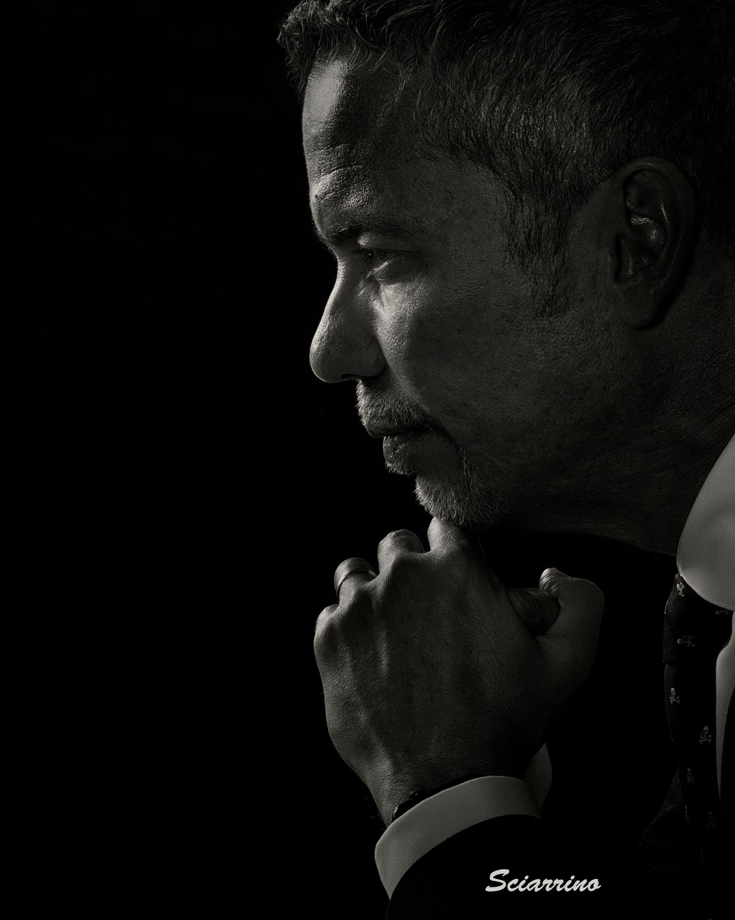 A series of dramatic black and white profile portraits showing silhouettes against a dark background.