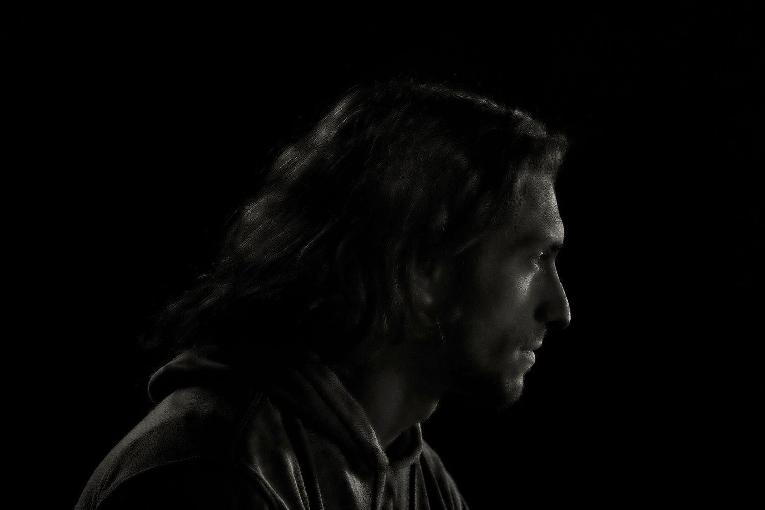 A person in a dark setting shown from multiple angles with dramatic lighting and shadows.