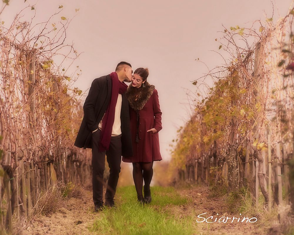 A couple shares romantic moments in an autumn forest setting during a golden hour photoshoot.