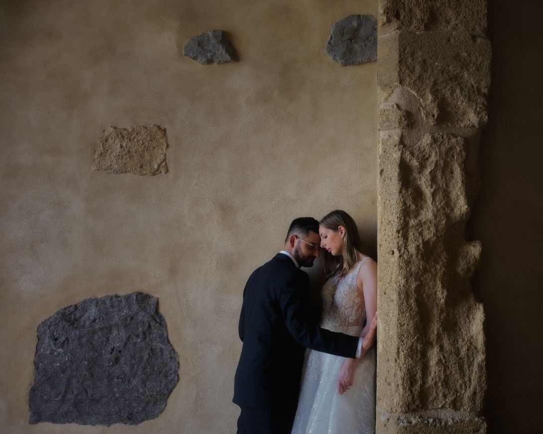 A romantic wedding photoshoot in a rustic stone corridor with dramatic lighting and textured walls.
Horvath-Photography-Sam-Sciarrino
