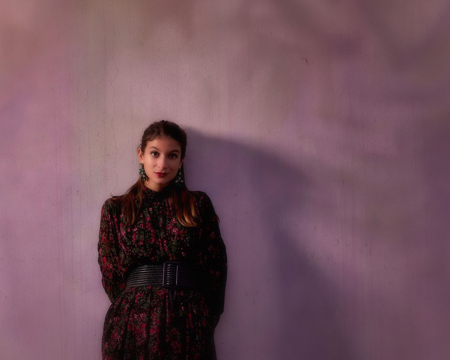 A series of fashion portraits against a purple background showing someone wearing a dark patterned top.