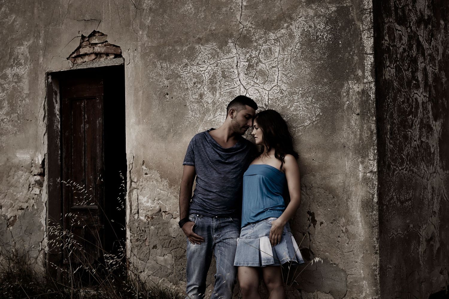 A couple embraces against a weathered concrete wall in an artistic black and white photograph.
Horvath-Photography-Sam-Sciarrino
