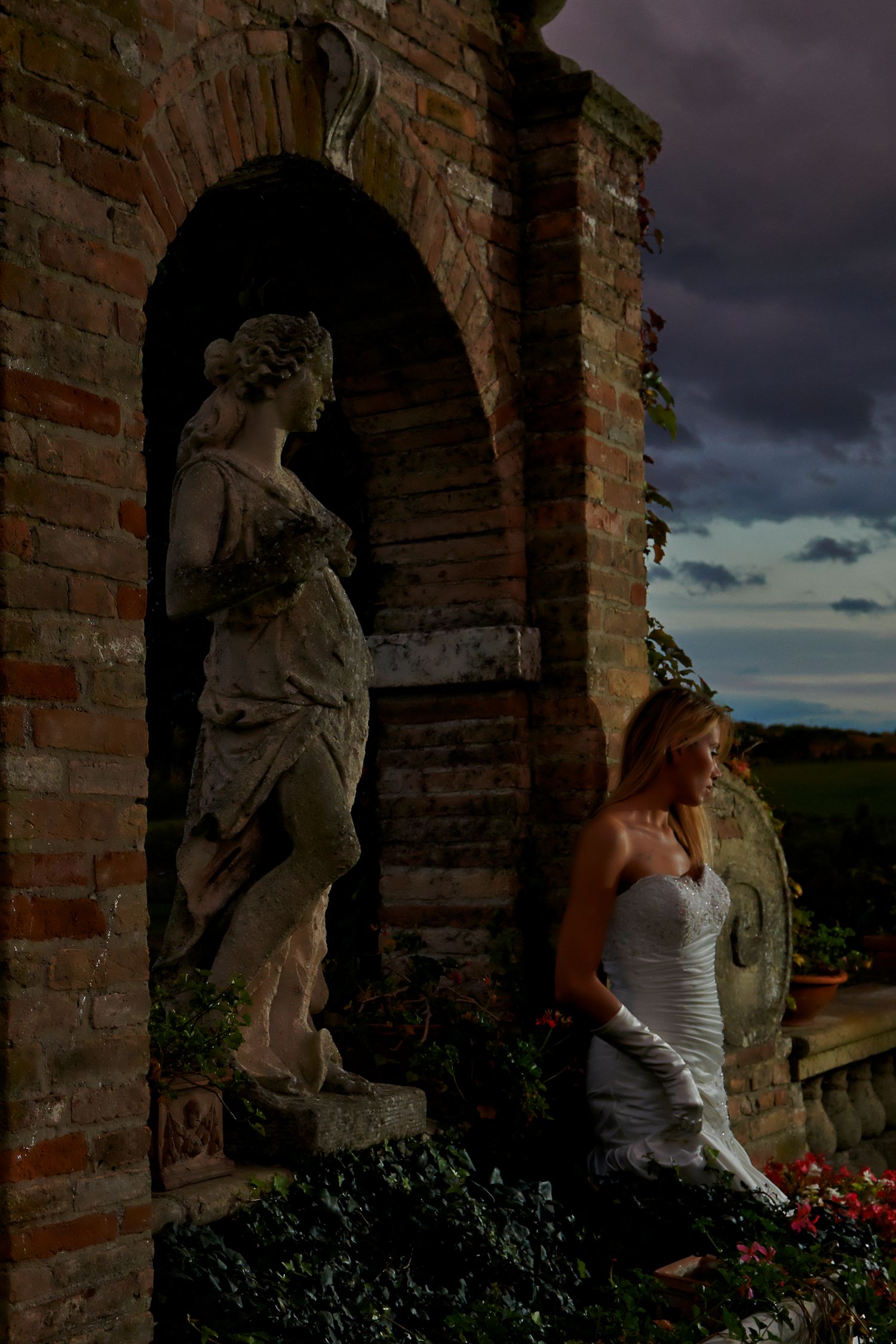 Dramatic stone archways and statues against a moody cloudy sky in a series of architectural photographs.