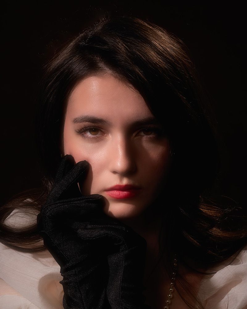Dramatic portrait series with moody lighting showing dark shadows and red lipstick against black background.
