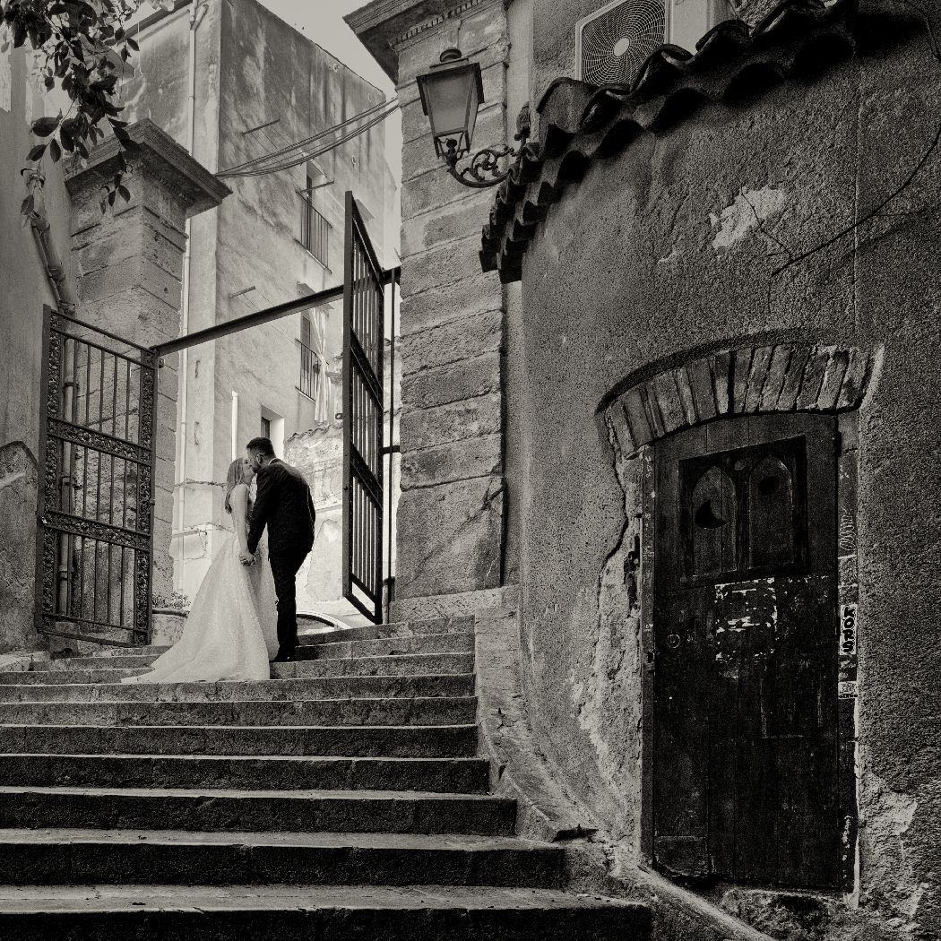 A couple ascends stone steps between historic buildings with a vintage street lamp on a misty day.
Horvath-Photography-Sam-Sciarrino