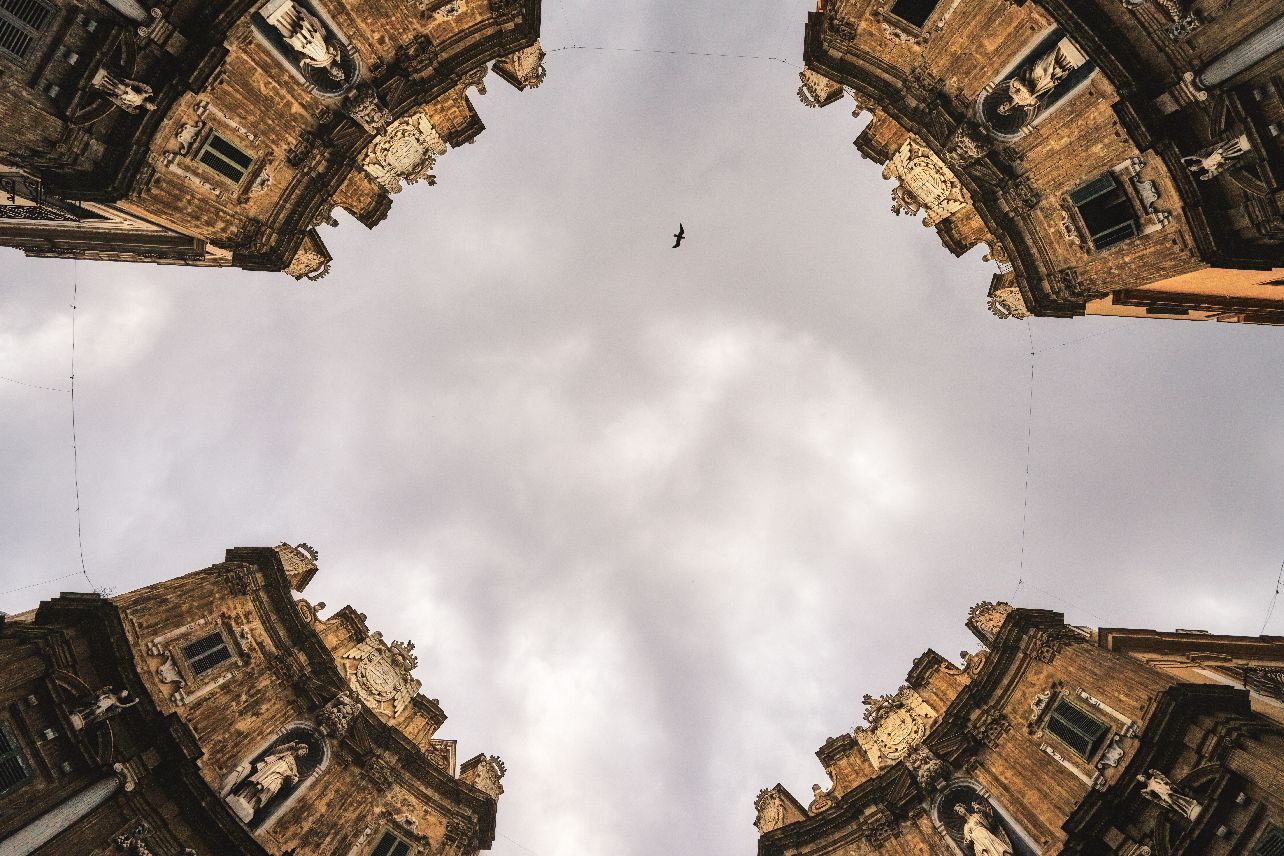 Gothic architectural details of ornate stone buildings shot from a low angle against cloudy sky in Edinburgh, Scotland.