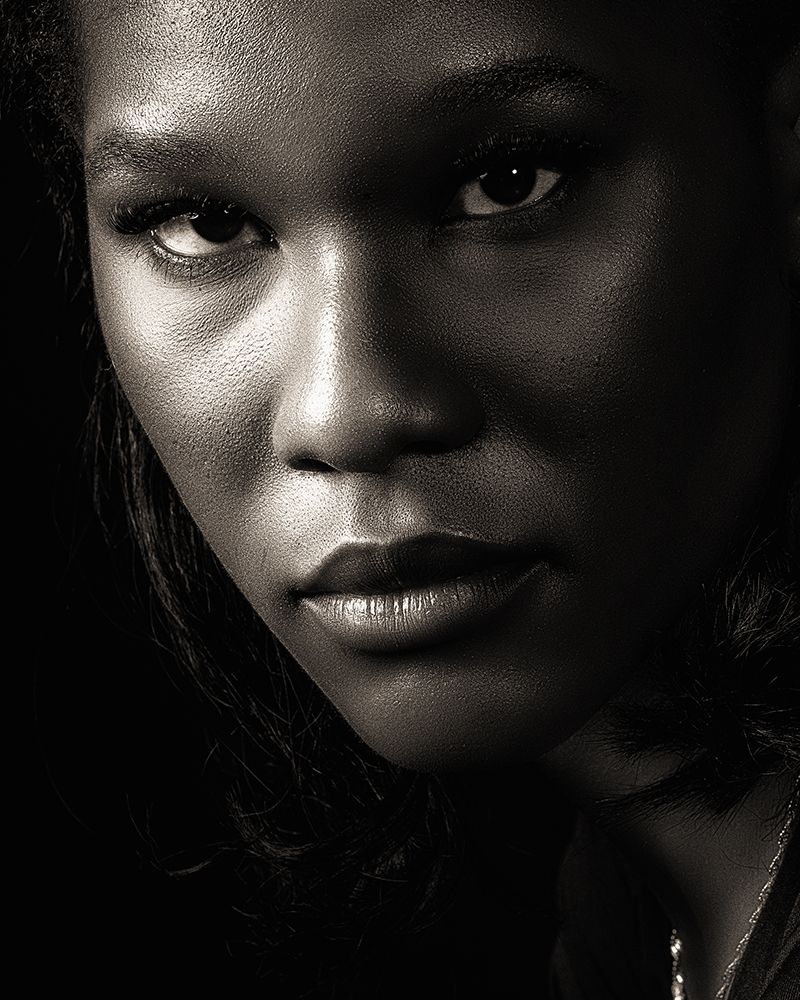 Dramatic black and white close-up portraits showing intense eyes and expressive features in dark lighting.
