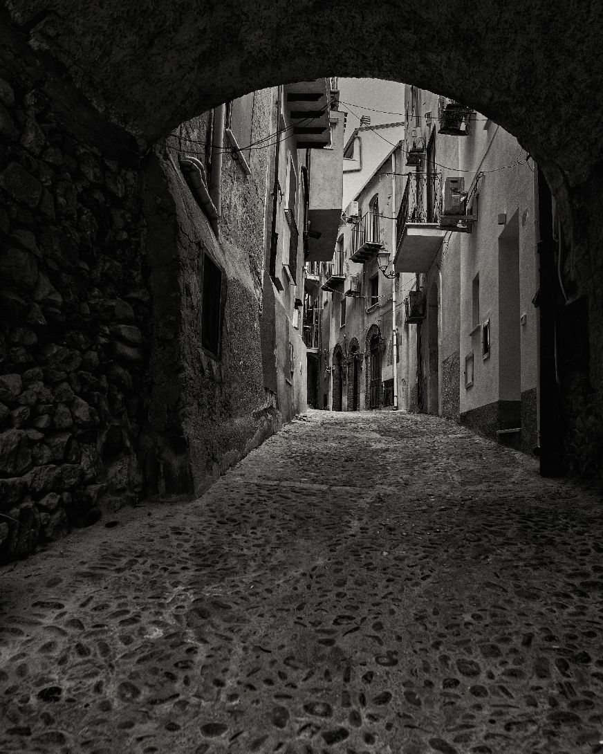 A series of narrow cobblestone alleyways in a medieval European town shown in black and white photography.
Horvath-Photography-Sam-Sciarrino