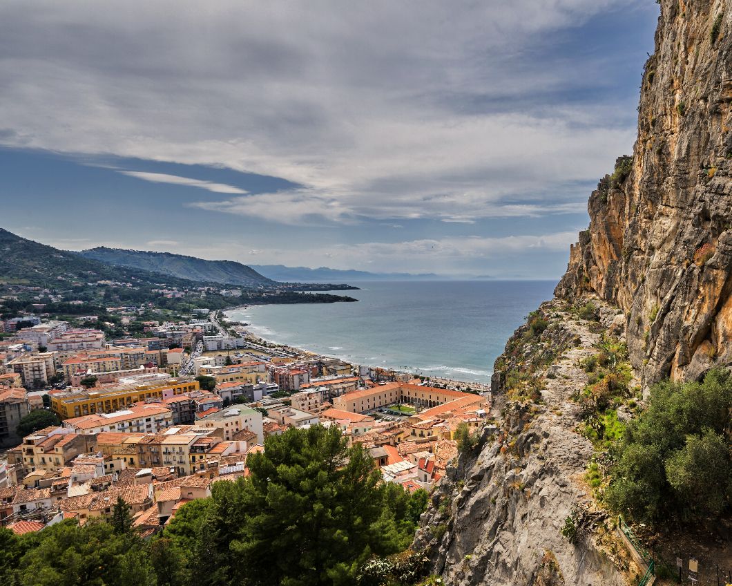 Scenic coastal cityscape of Cefalu, Sicily with dramatic cliffs overlooking the Mediterranean town.