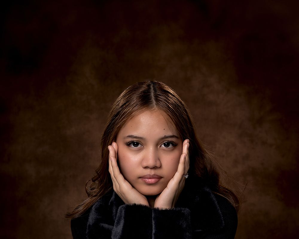 Dark and moody portrait series featuring dramatic lighting and black attire.