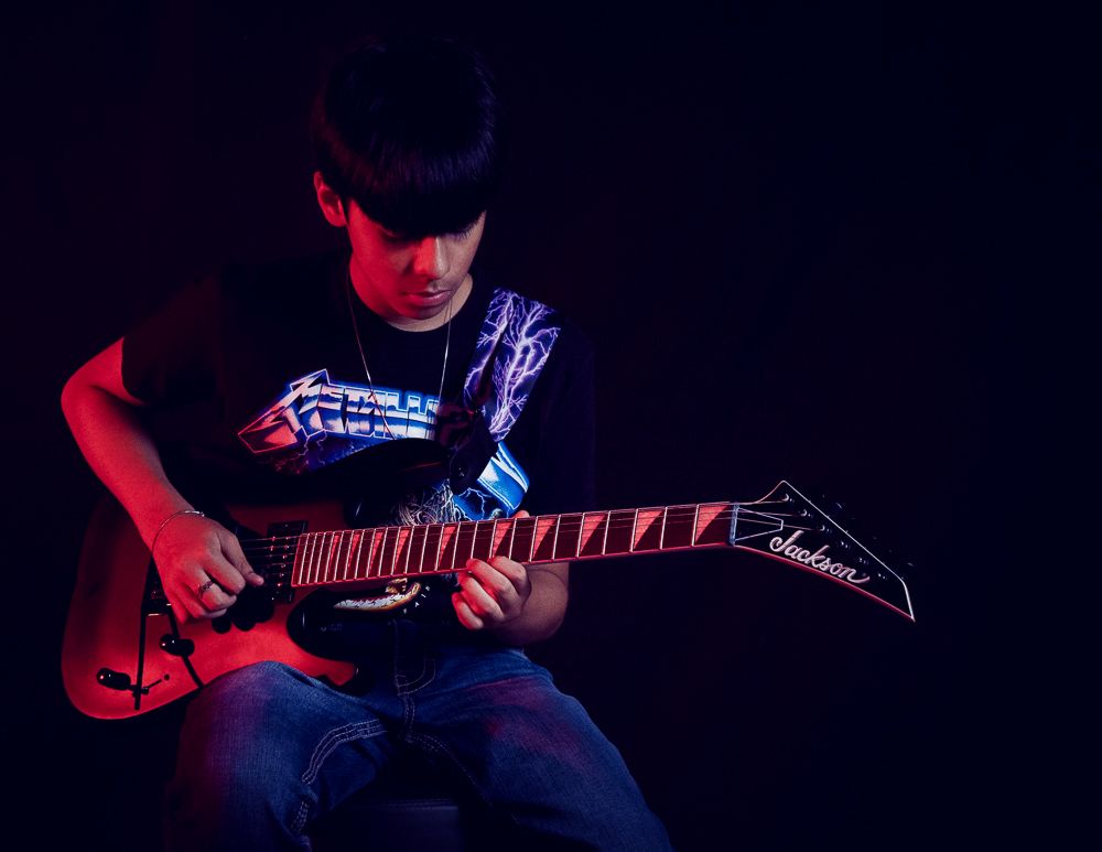 Moody editorial portrait of young musician with electric guitar by creative portrait photographer in Atlanta, APQ Creative.