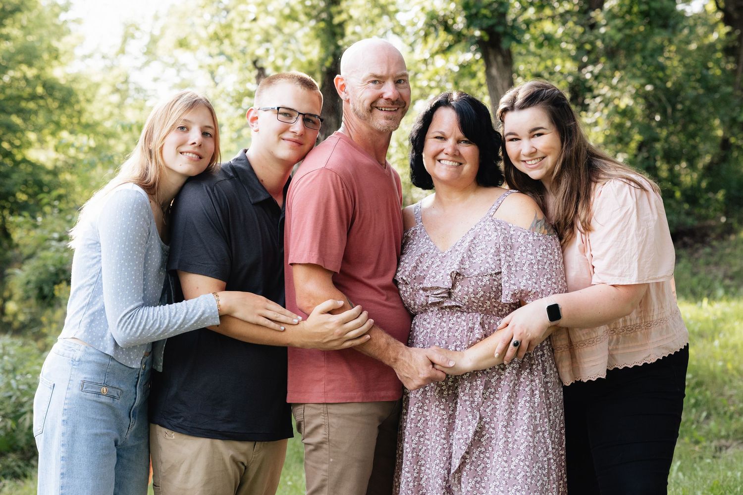 A group poses together outdoors for a casual family photo.