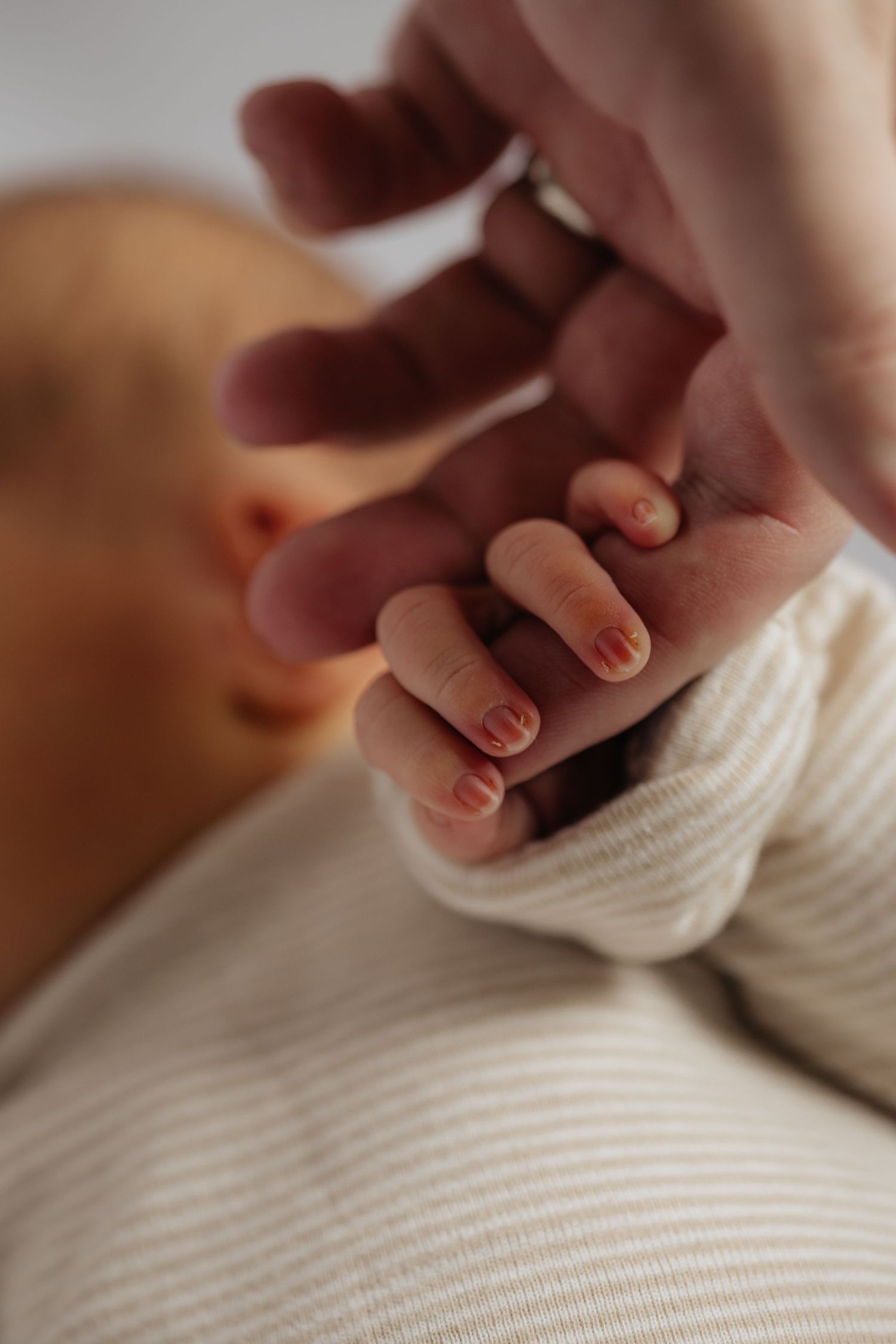 Close-up of gentle hands touching soft white fabric.