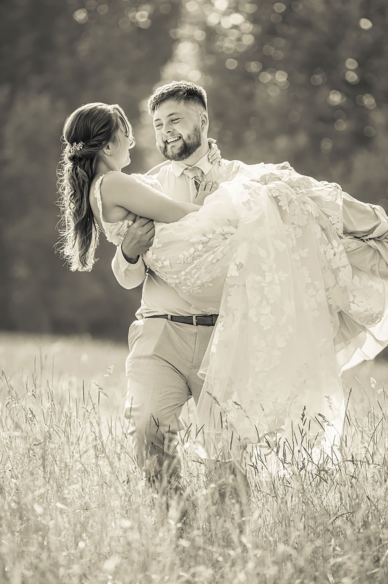 Romantic black and white photo of couple embracing in hay  field at Walnut Barn Estate near Burnham photographed by Sophie Edmunds.