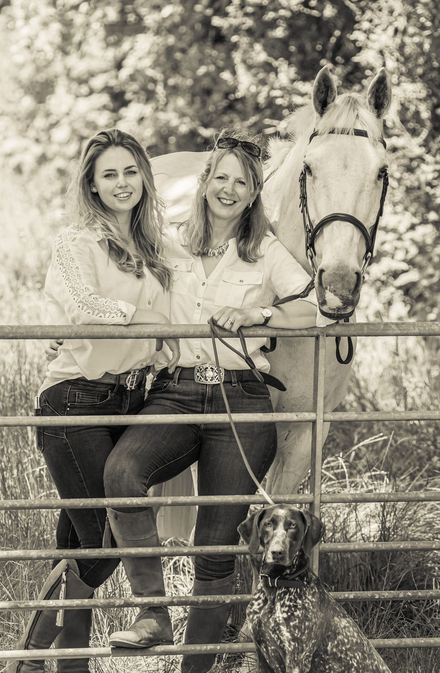 Black and white photo series of two women and a horse posing together at a rustic wooden fence with a dog nearby.