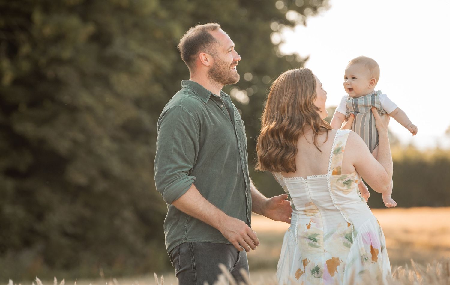 A couple sharing romantic moments with their newborn during a golden hour photoshoot on their family farm in the Cotswolds.