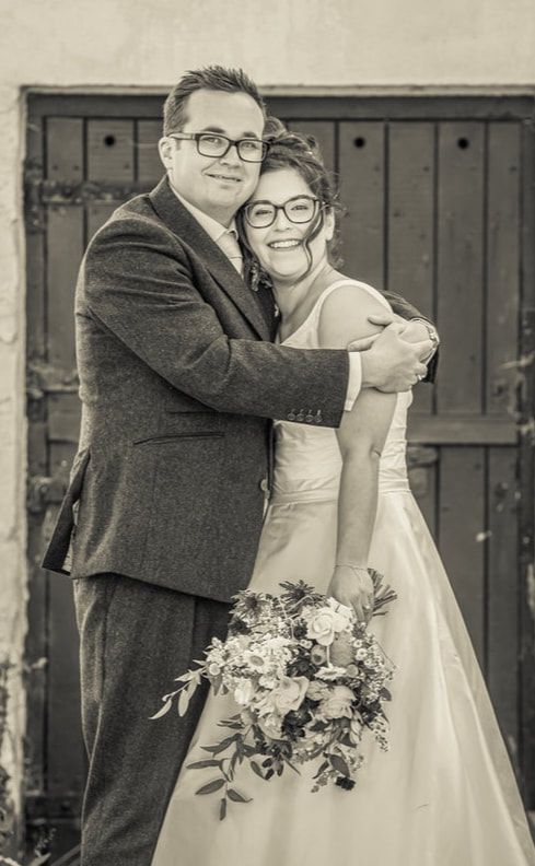 Black and white wedding photo sequence showing couple embracing with bride holding floral bouquet against rustic backdrop.