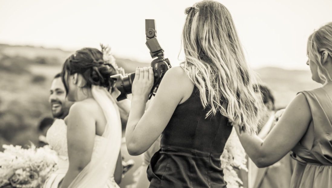 A collage of black and white wedding photos showing candid moments of guests and couples dancing and celebrating.