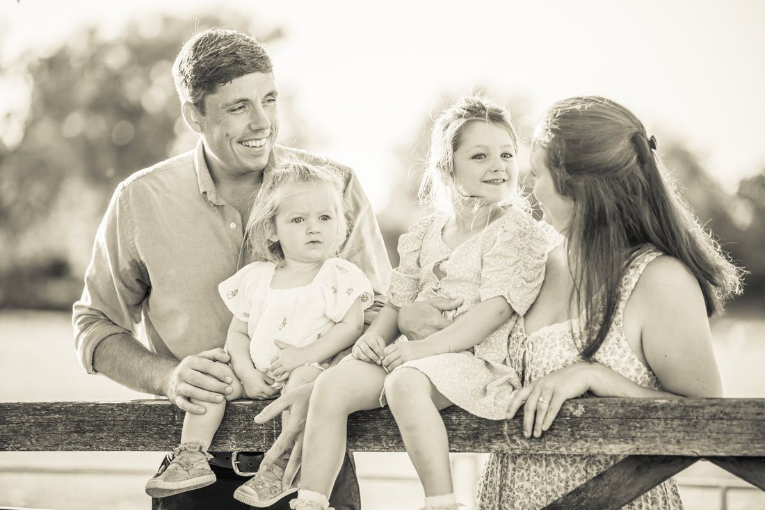 A series of black and white family photographs showing tender moments between parents and children playing outdoors.