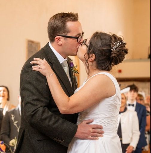 A couple shares a romantic dance together at a wedding reception in formal attire.
