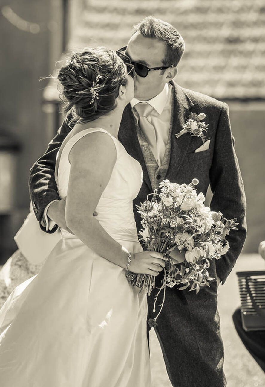 Black and white wedding photo series showing romantic moments between newlyweds with bridal bouquet and flowing dress.