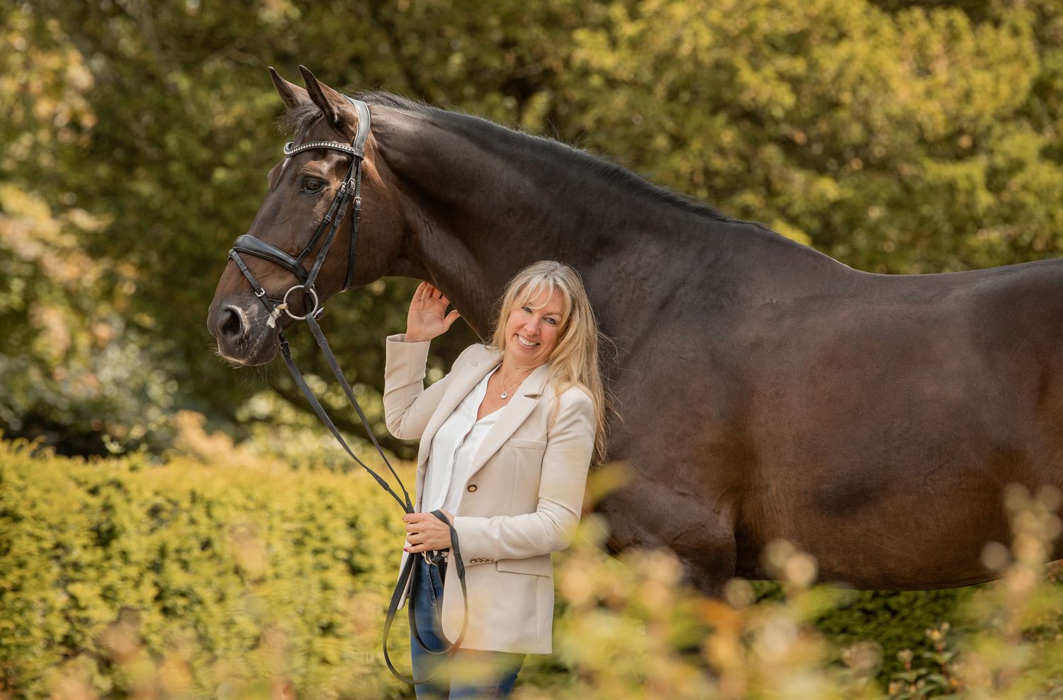 Beautiful horse and dressage rider Fiona Bigwood, posing together in an outdoor autumn setting.