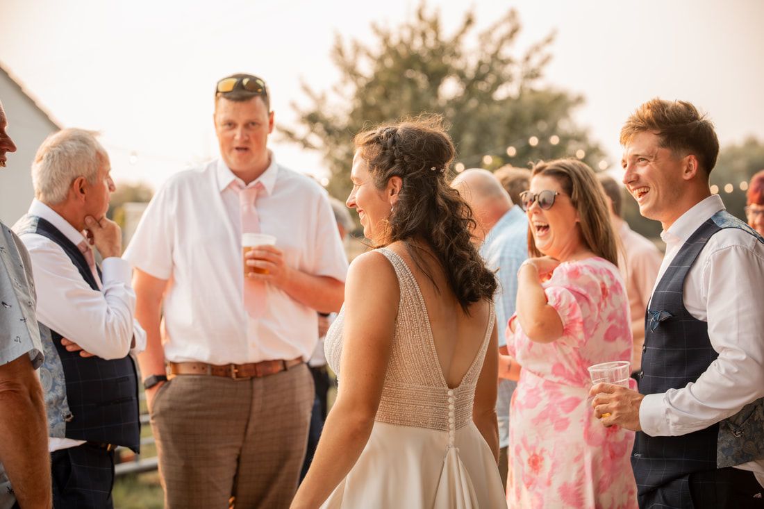 Wedding guests dance and celebrate together on an outdoor dance floor during a joyful reception celebration.