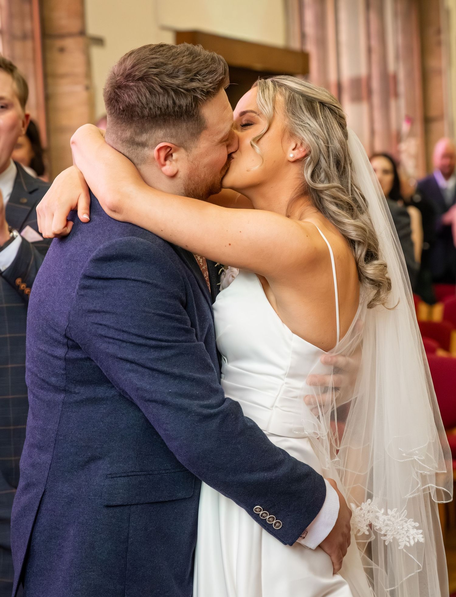 Bride and groom share their first kiss at the altar during a church wedding ceremony.