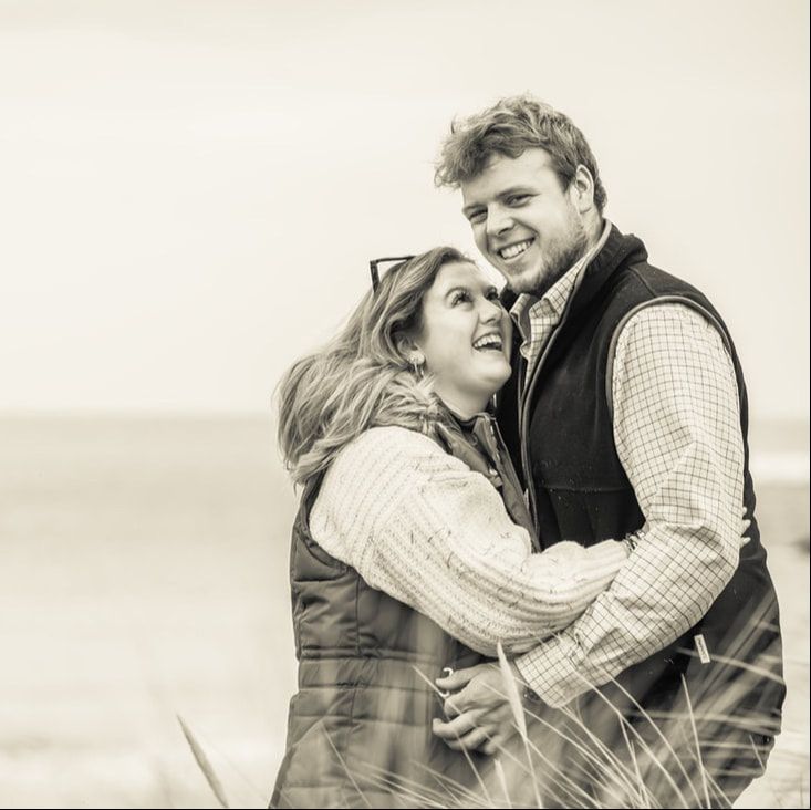 A couple embraces and laughs together in a romantic black and white photo series.