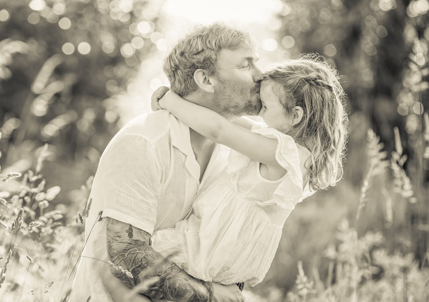 A romantic black and white portrait captured in a sunlit meadow on their farm property in Somerset.