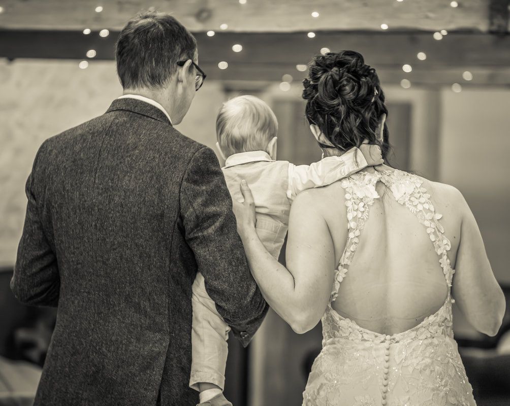 A series of black and white wedding photos showing details of bridal gowns and formal attire at a reception.