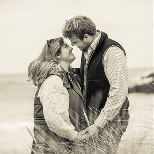A romantic black and white photo series showing a couple embracing in a wheat field.