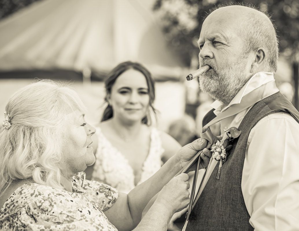 A series of black and white candid photos showing joyful moments at an outdoor wedding celebration.