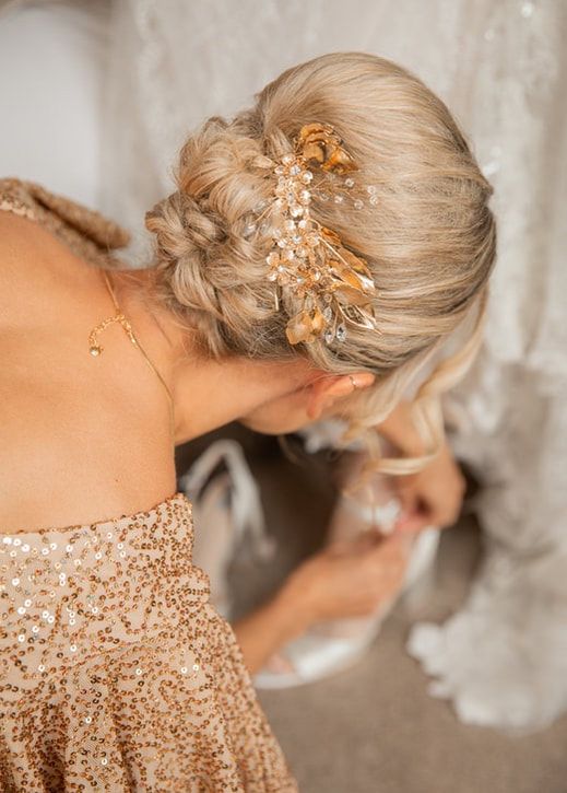 Close-up view of elegant bridal hairstyle with rose gold hair accessories and sequined dress details.