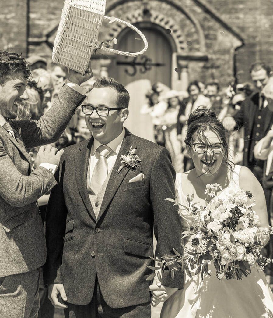 A black and white wedding photo sequence showing candid moments between the couple and guests at an outdoor celebration.