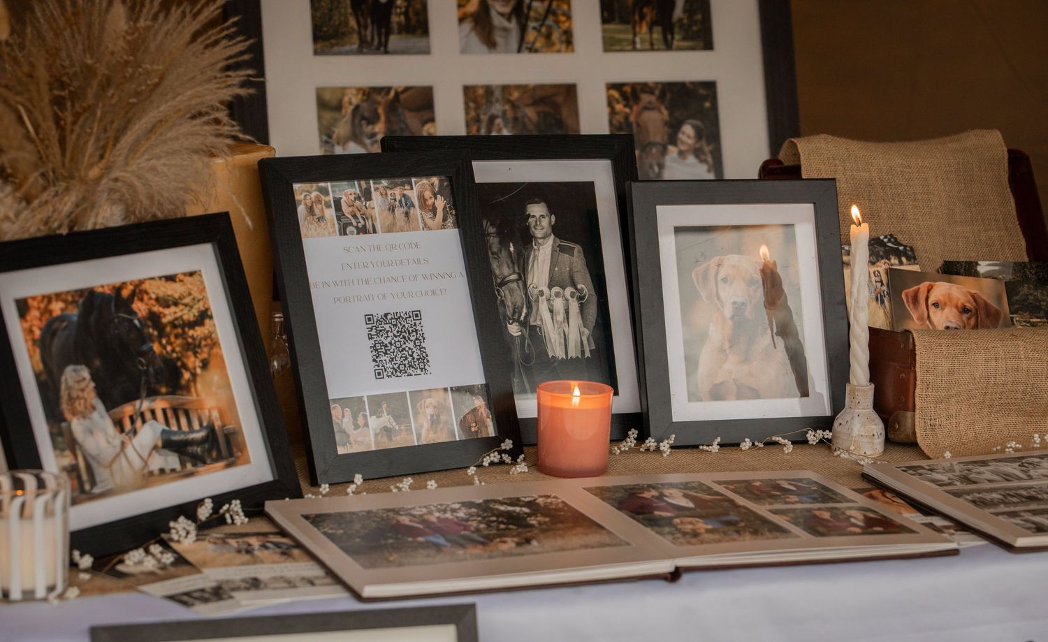 Wedding memory table with framed photos, candles, and a guest book display at a romantic reception.