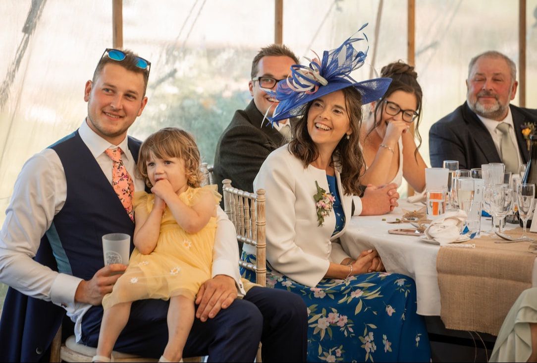 Wedding guests enjoying a celebratory meal and conversation at a reception banquet table.