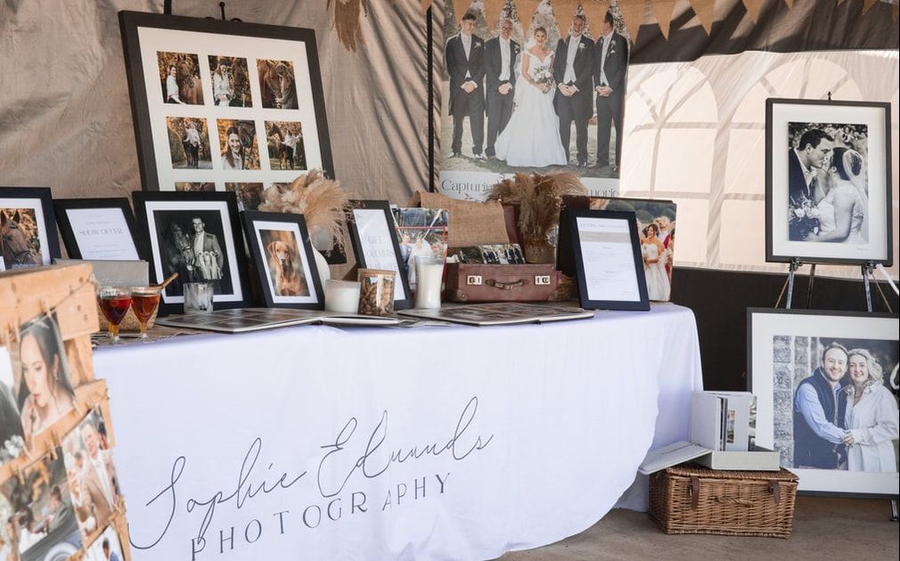 A collection of vintage-style photographs and frames arranged on a wall in a gallery display format.