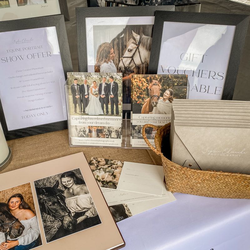 Professional photography display with printed photos and text layouts on a white tablecloth.