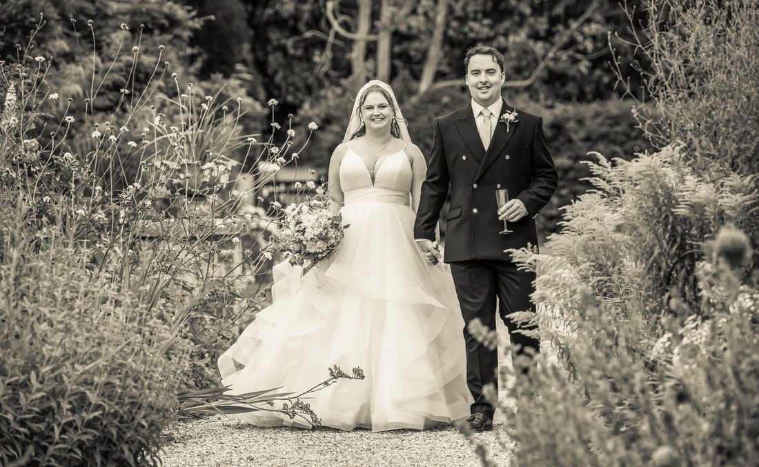 A romantic wedding couple poses in a garden setting captured in a series of black and white photographs.